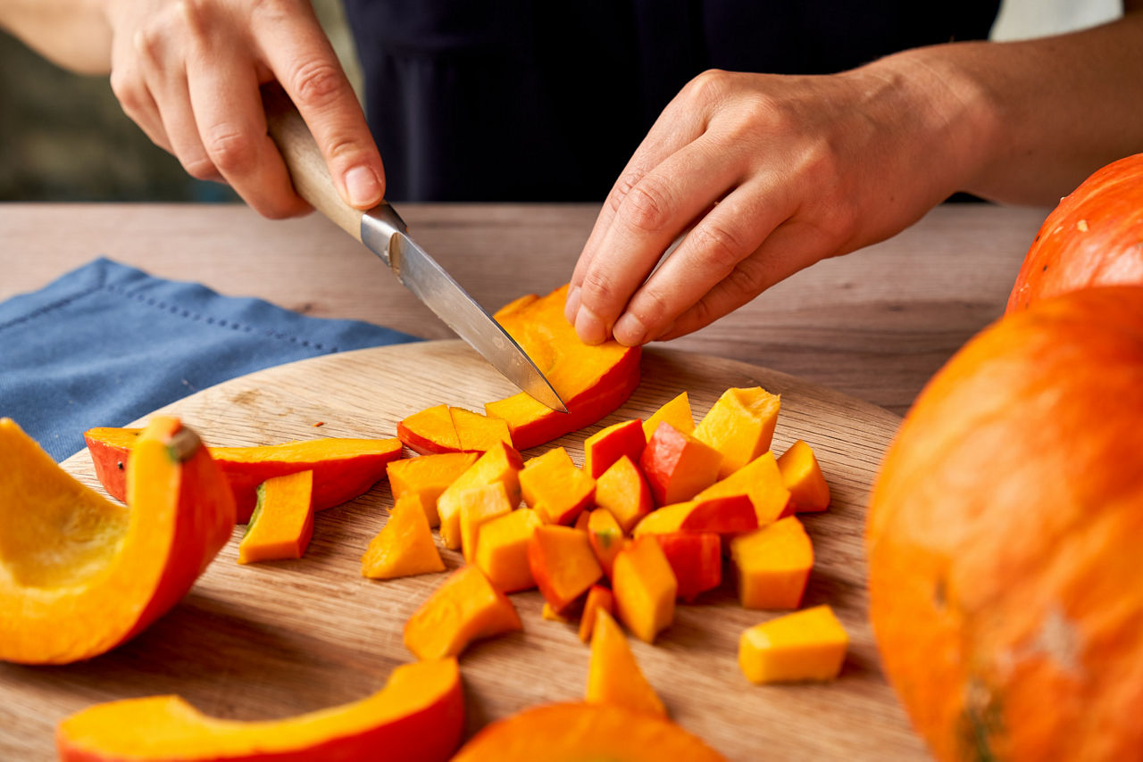Remolacha roja cortada con un cuchillo sobre una tabla de madera