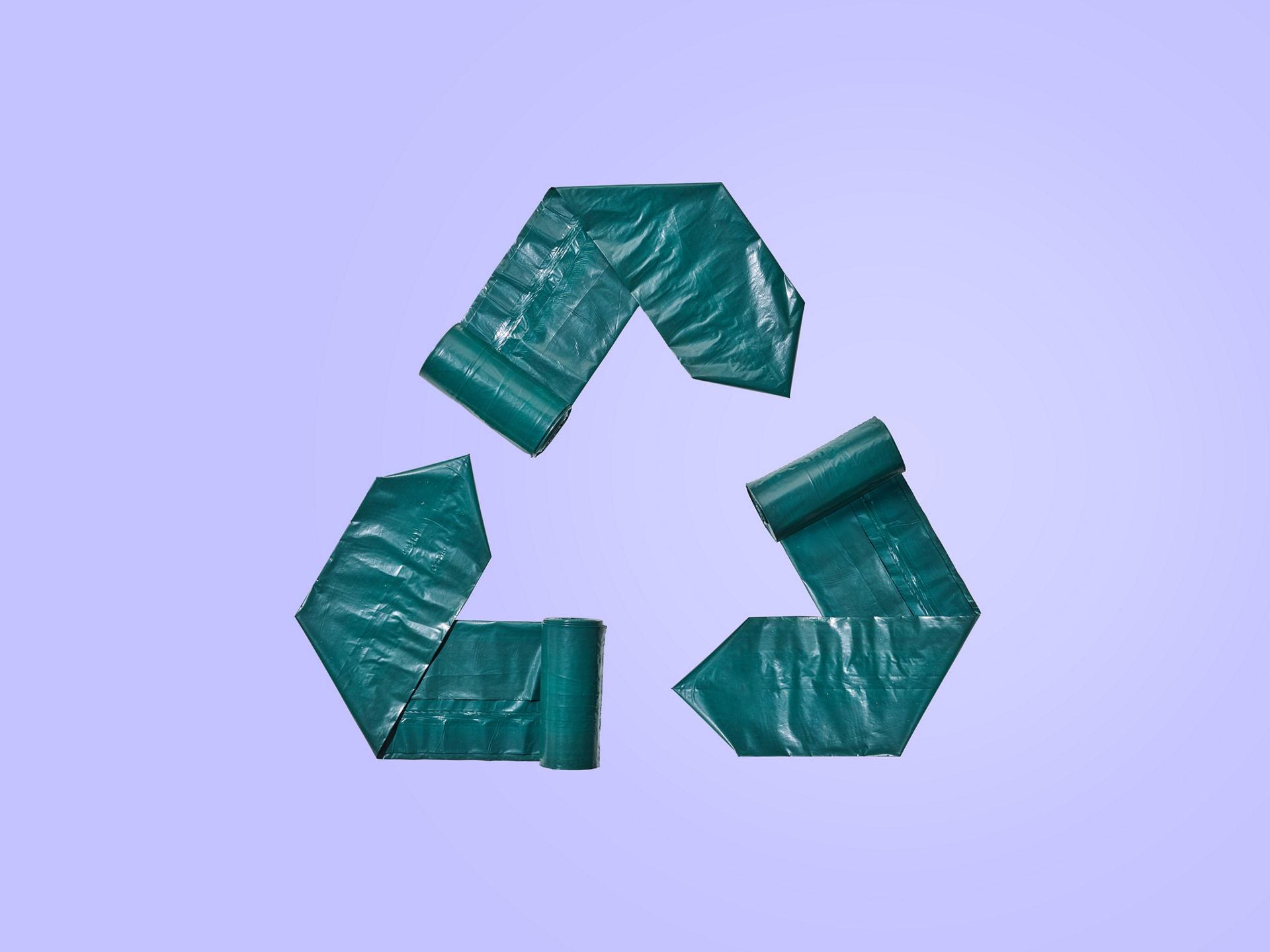 3 Banderolen aus dunkelgrünen Müllbeuteln bilden ein Recycling-Symbol