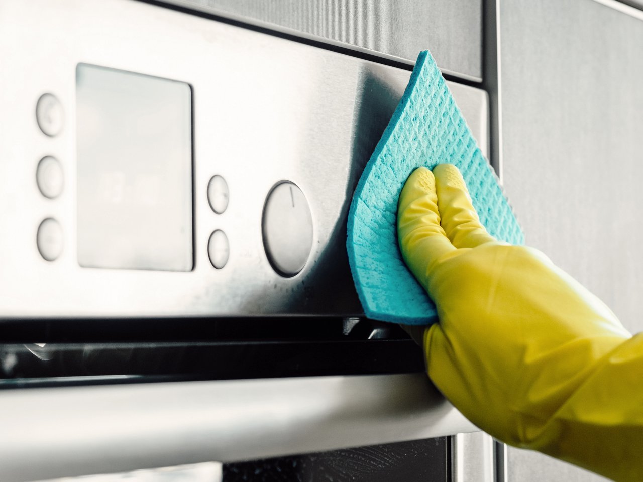 Person putzt einen Backofen