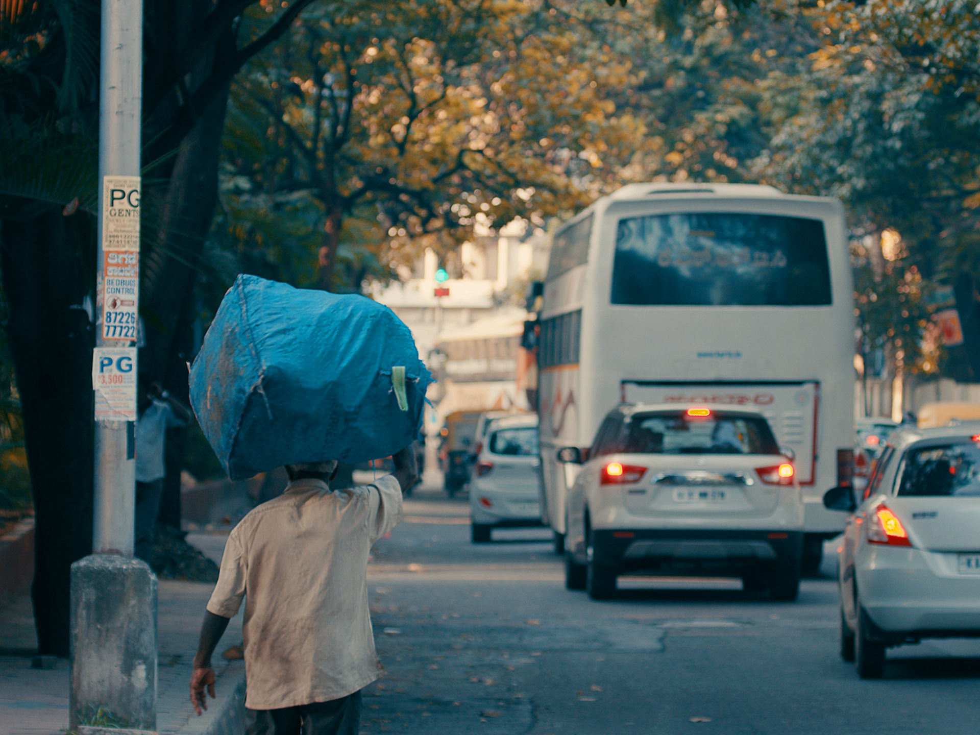 Wastepicker läuft mit gefülltem Beutel durch die Straßen