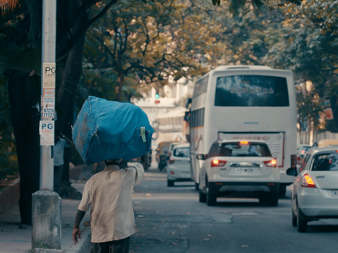 Wastepicker läuft mit gefülltem Beutel durch die Straßen