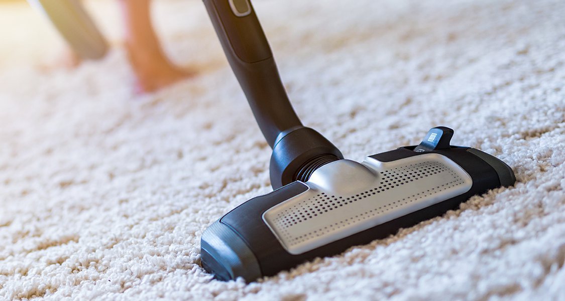 Tête d’aspirateur traîneau nettoyant un tapis beige