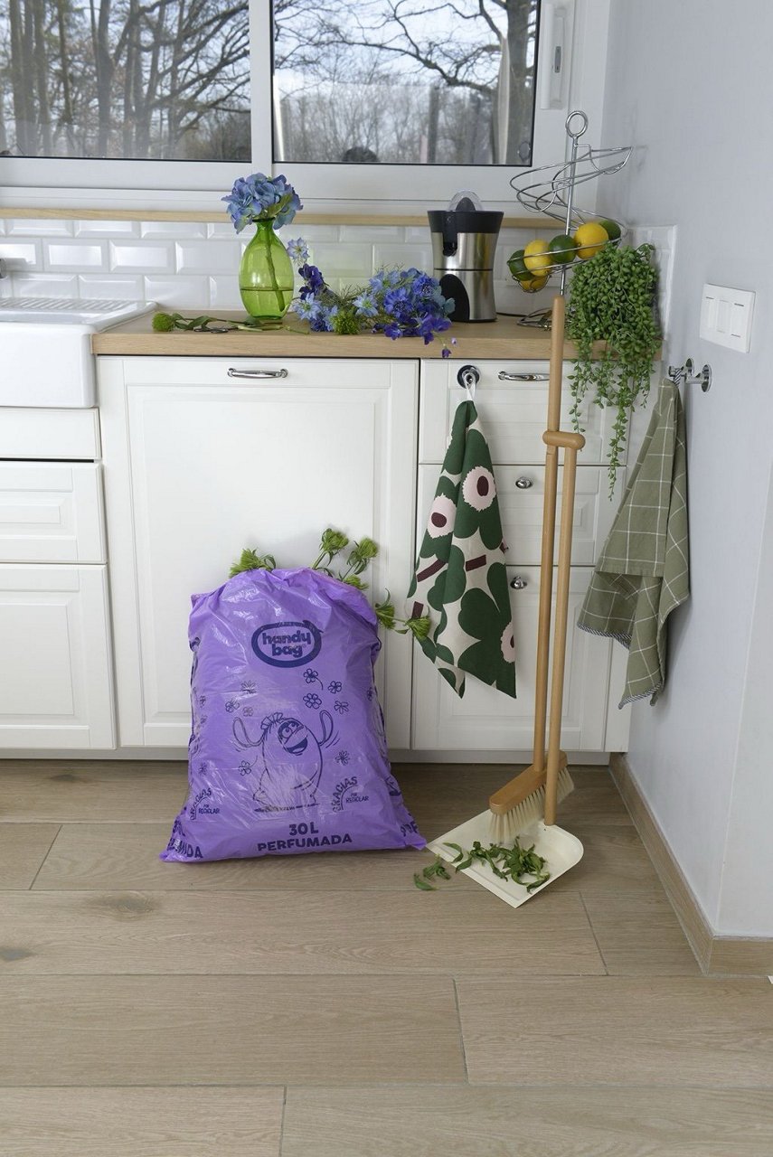 Bolsa de basura Handybag de 30 litros llena colocada en el suelo de una cocina
