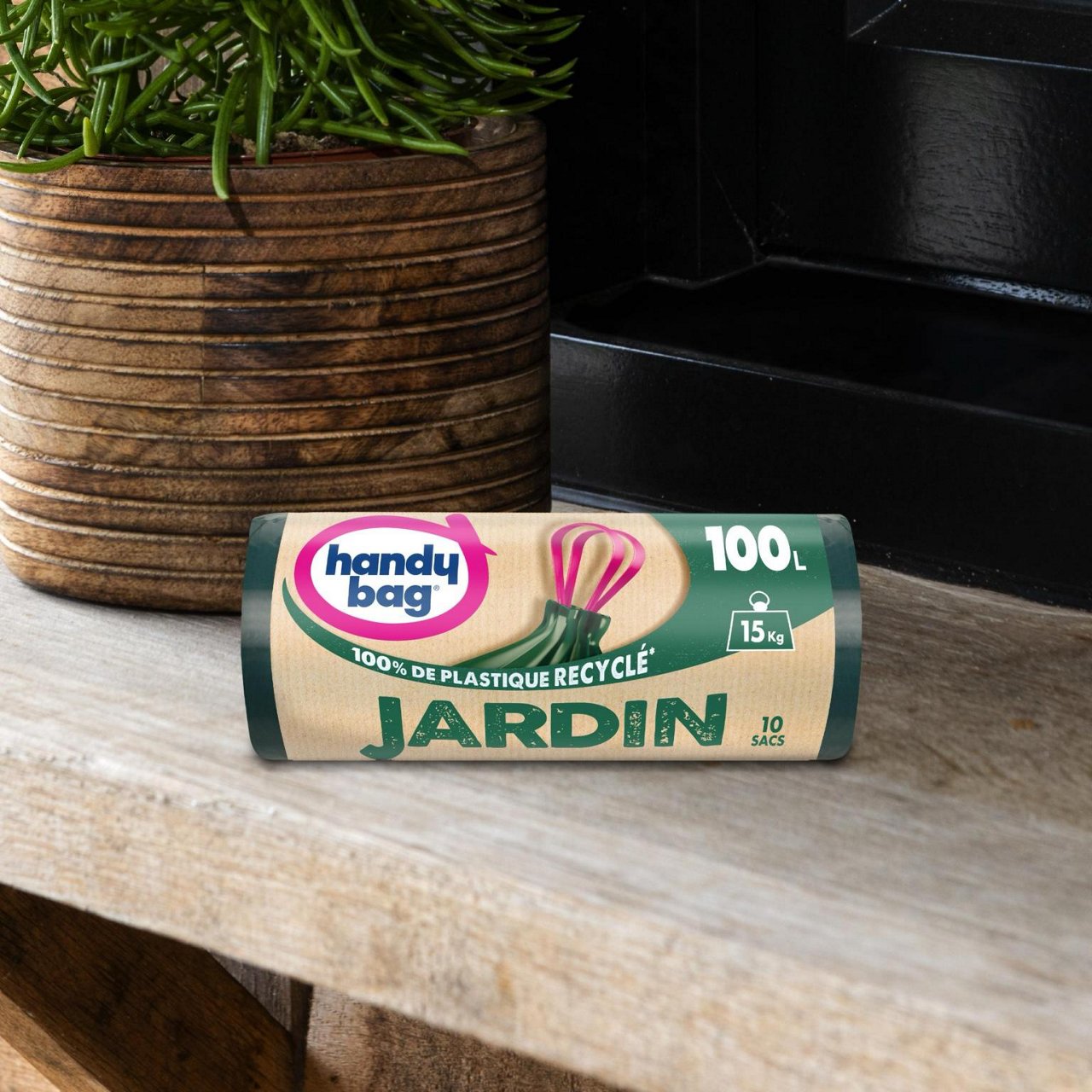Emballage de sac poubelle Handybag jardin 100 litres posé devant une plante décorative