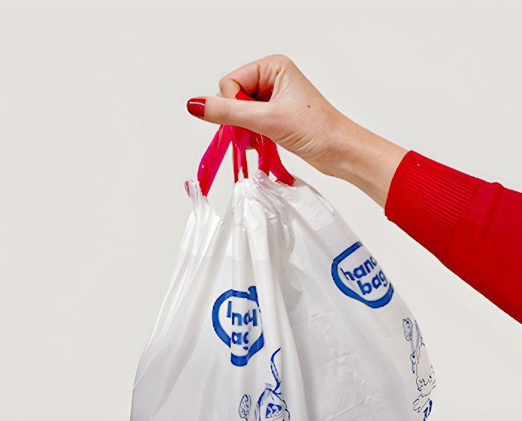Mano sosteniendo una bolsa de basura Handybag por sus asas deslizantes