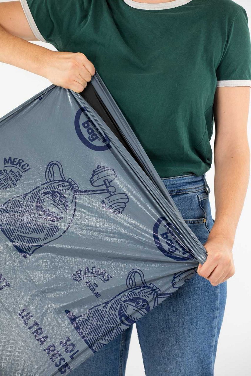 Personne tirant sur un sac poubelle Handybag à poignées coulissantes