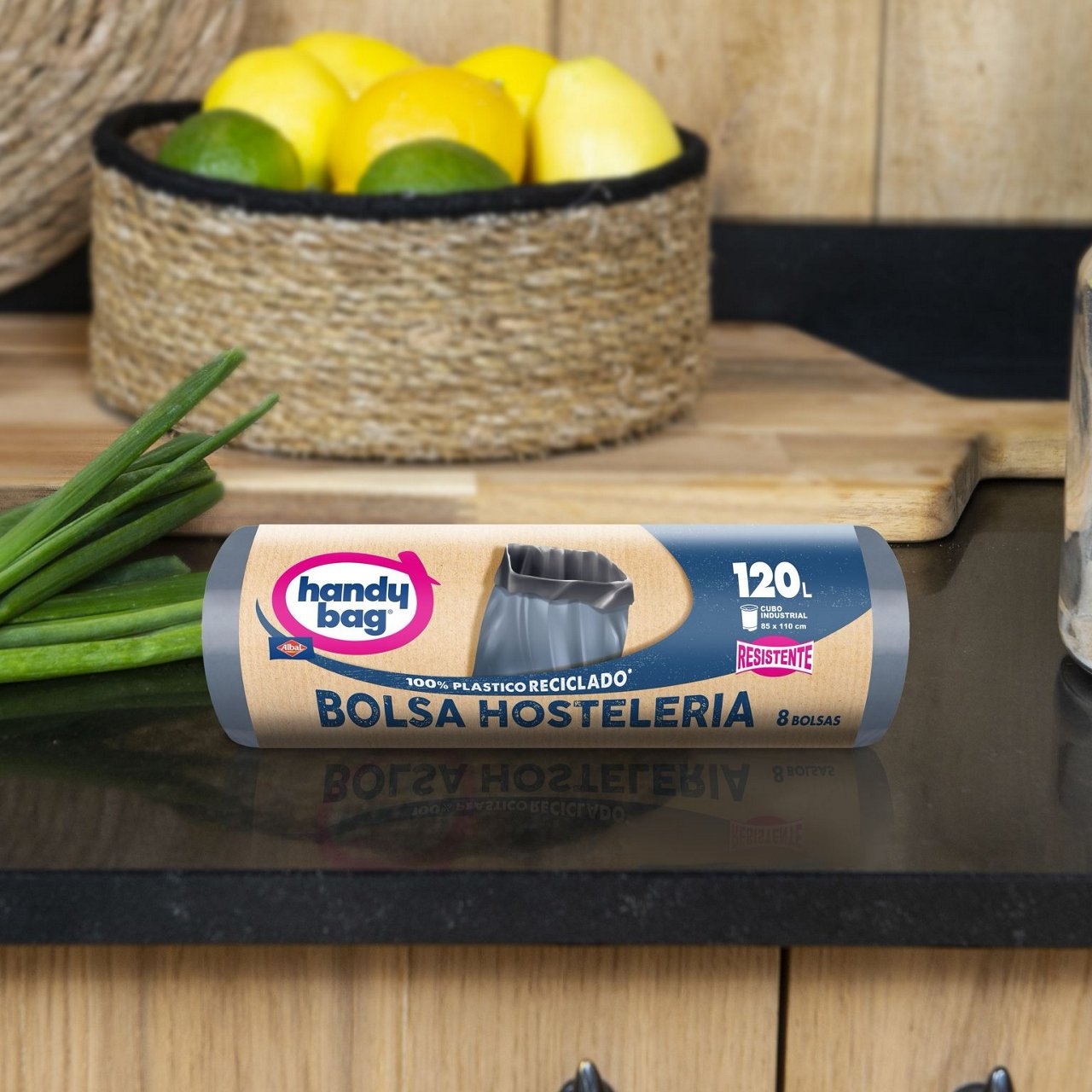 Bolsa de basura Handybag de 120 litros en rollo sobre una encimera con limones en el fondo