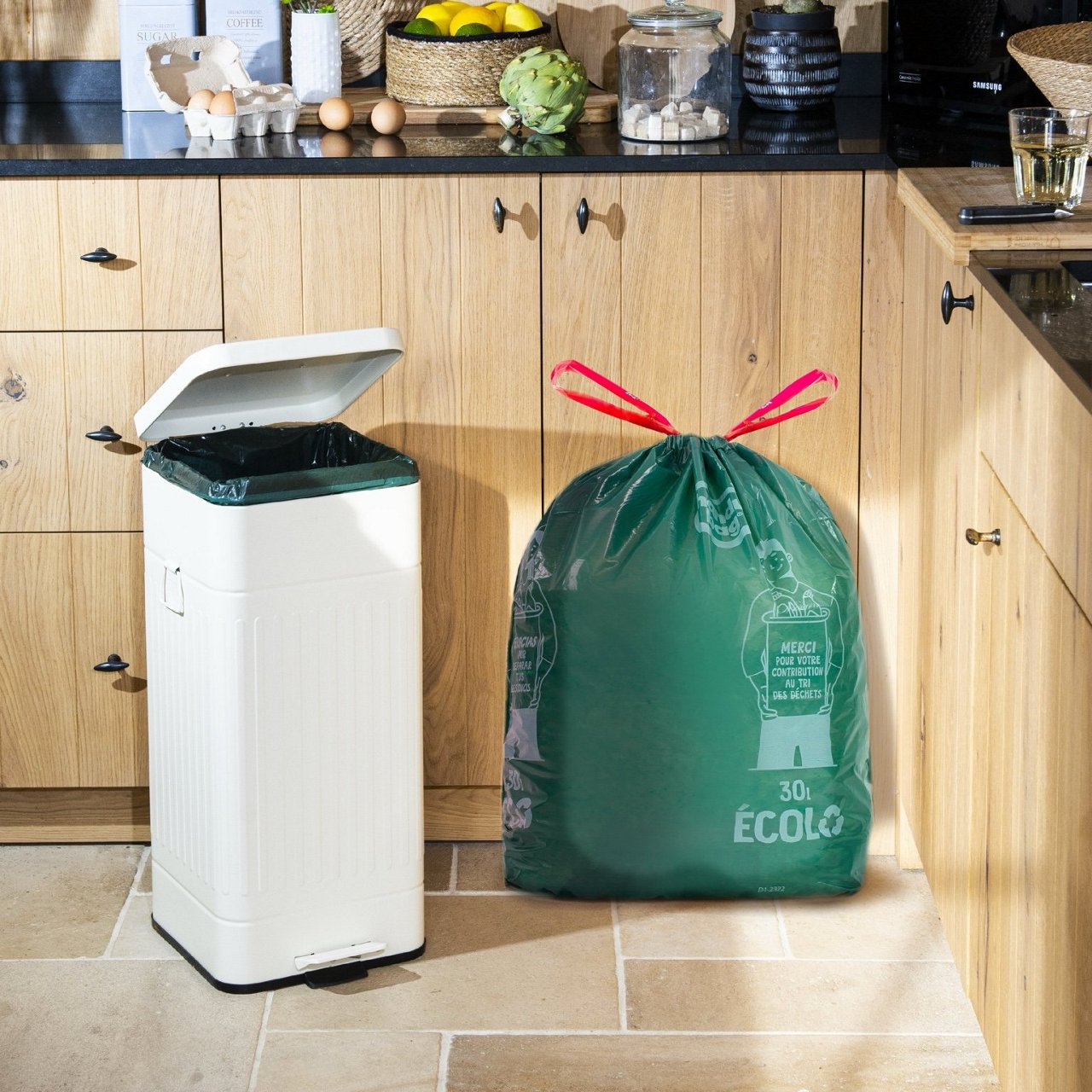 Sac poubelle Handybag écologique à fixations élastiques près d’une poubelle