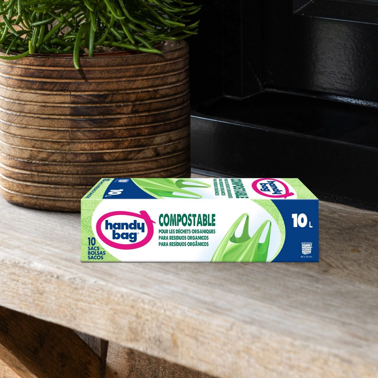 Boîte de sacs poubelle Handybag compostables 10 litres posée à côté d’une plante