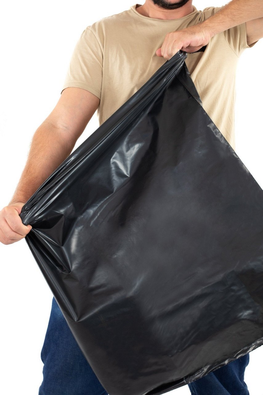 Homme étirant un sac poubelle Handybag très résistant pour gravats