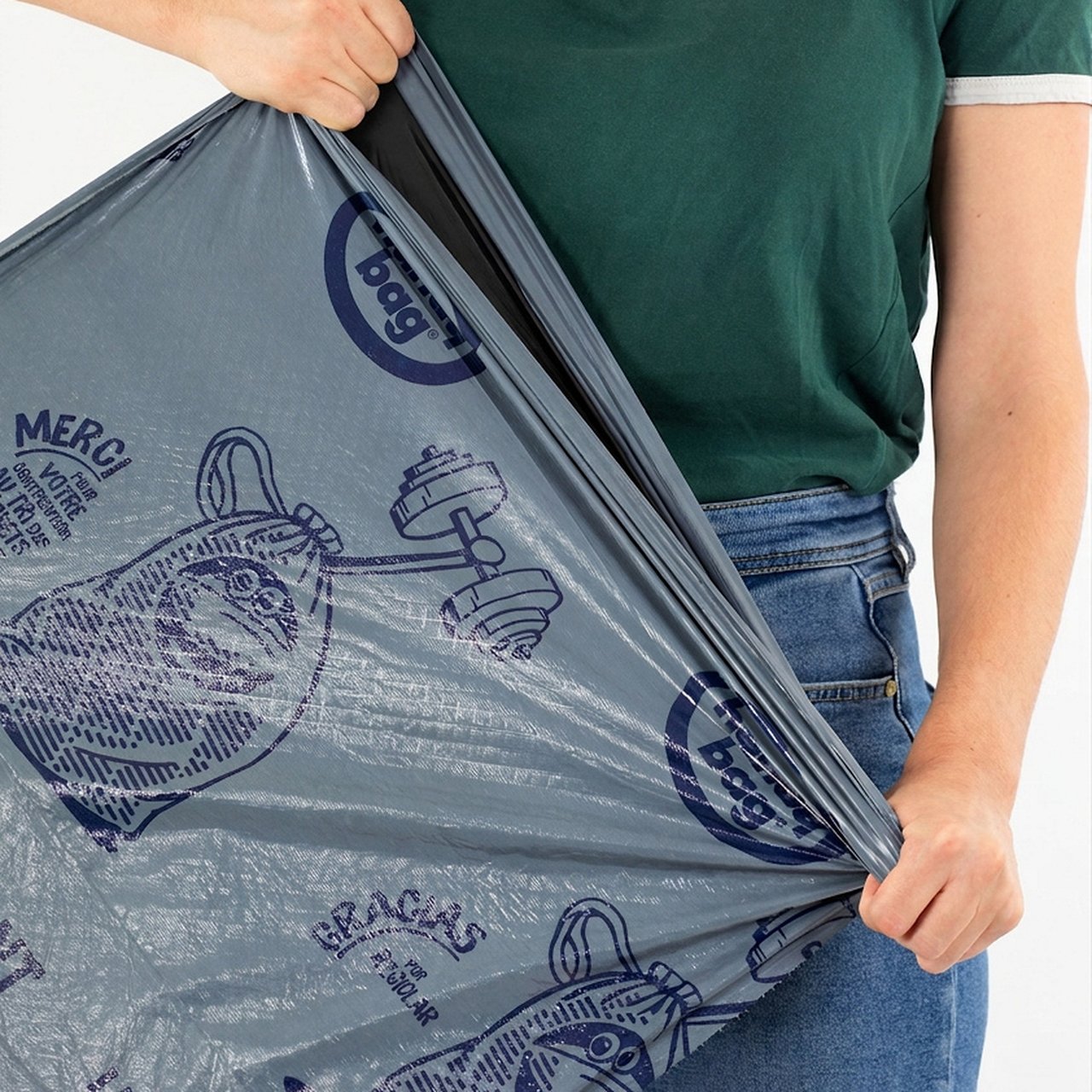 Personne tenant un sac poubelle gris Handy Bag devant un jean bleu