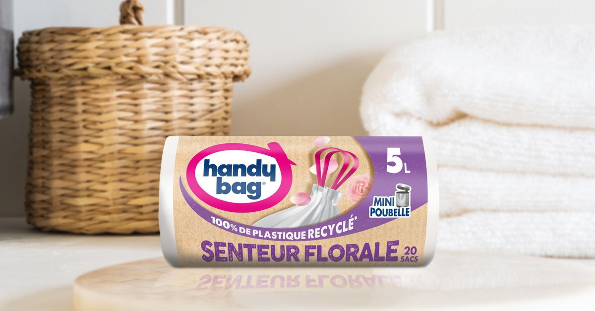 Rouleau de sac poubelle Handybag senteur florale 5 litres devant un panier en osier