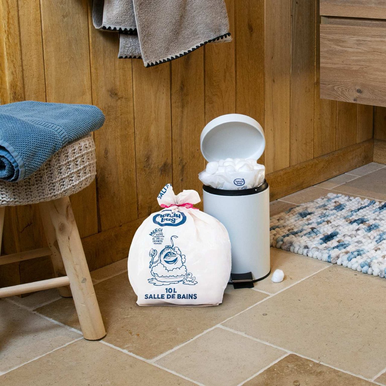 Sac poubelle Handybag 10 litres à côté d’une corbeille