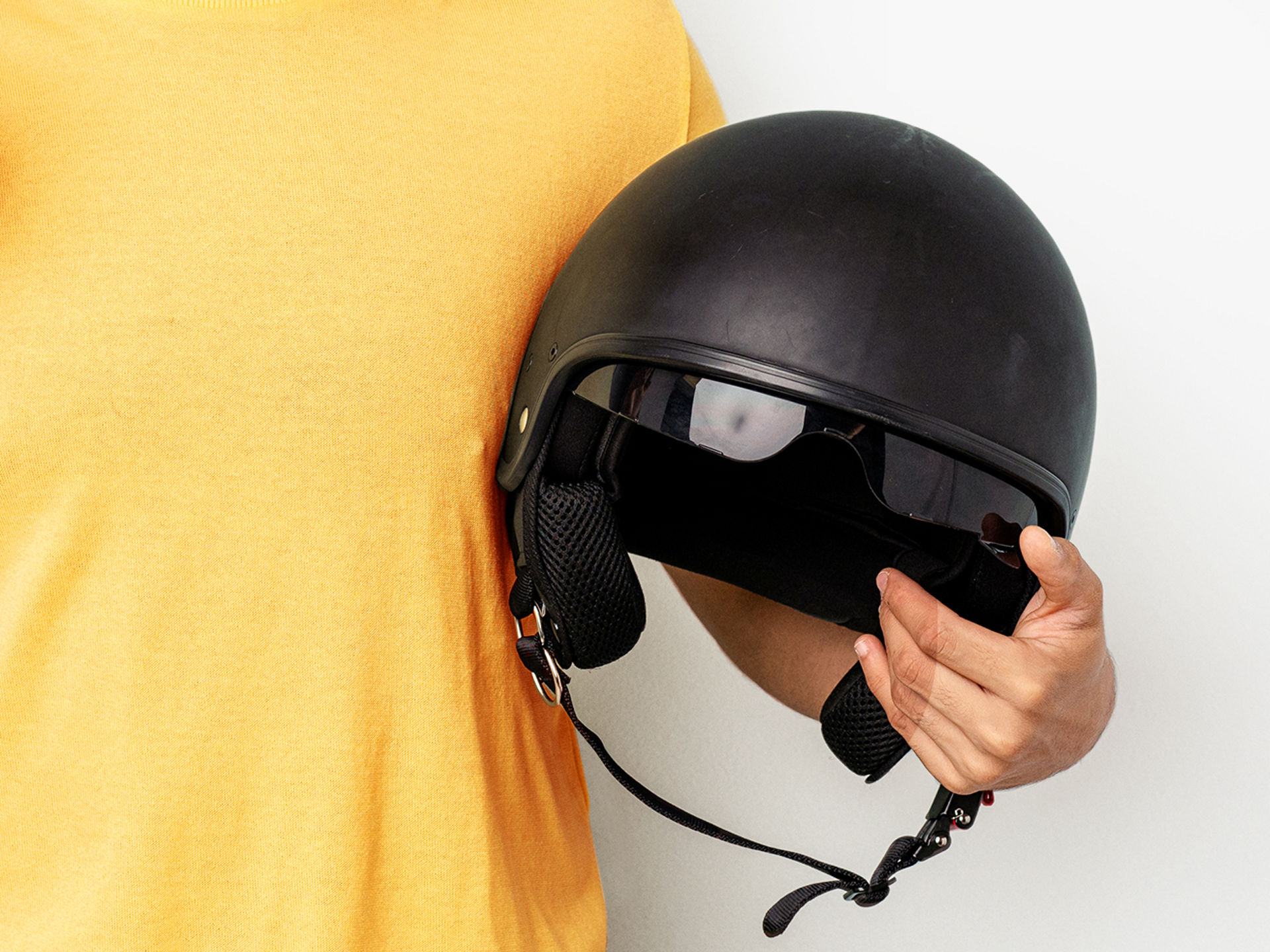 Person hält einen Motorradhelm im Arm