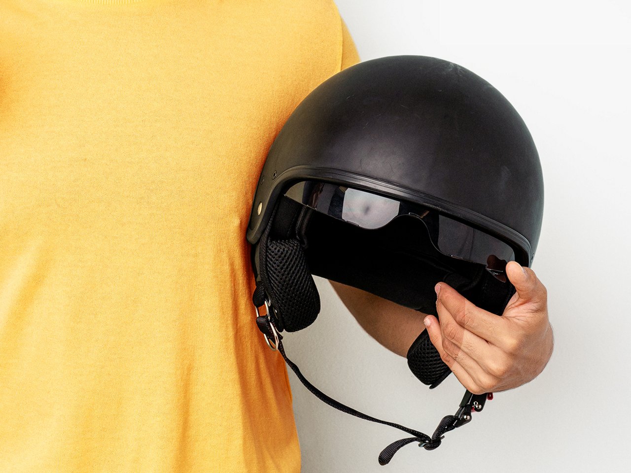 Person hält einen Motorradhelm im Arm