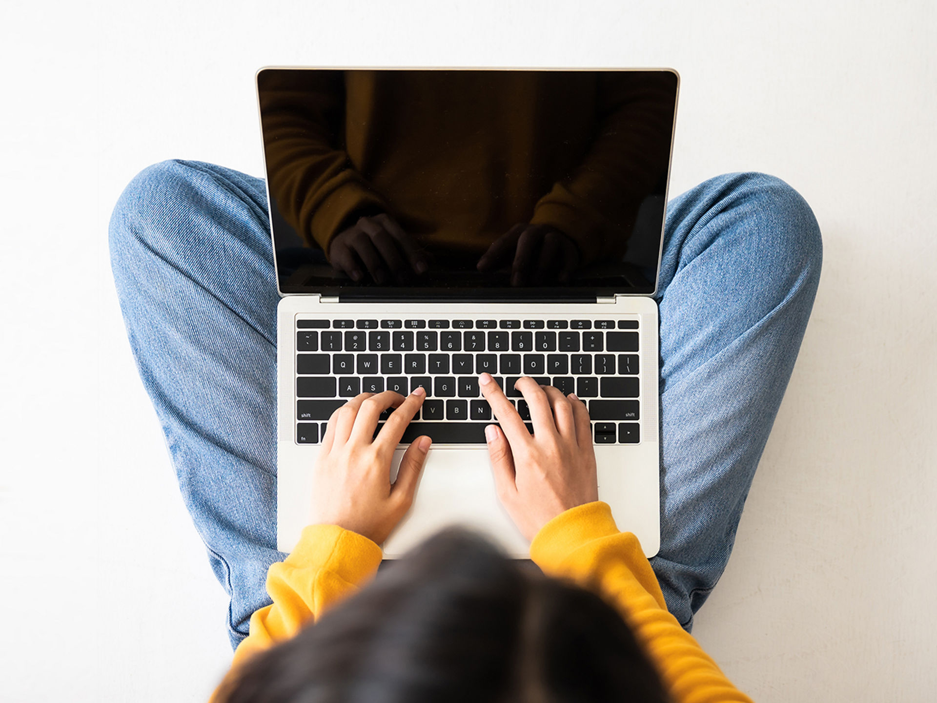 Person tippt auf einem Laptop