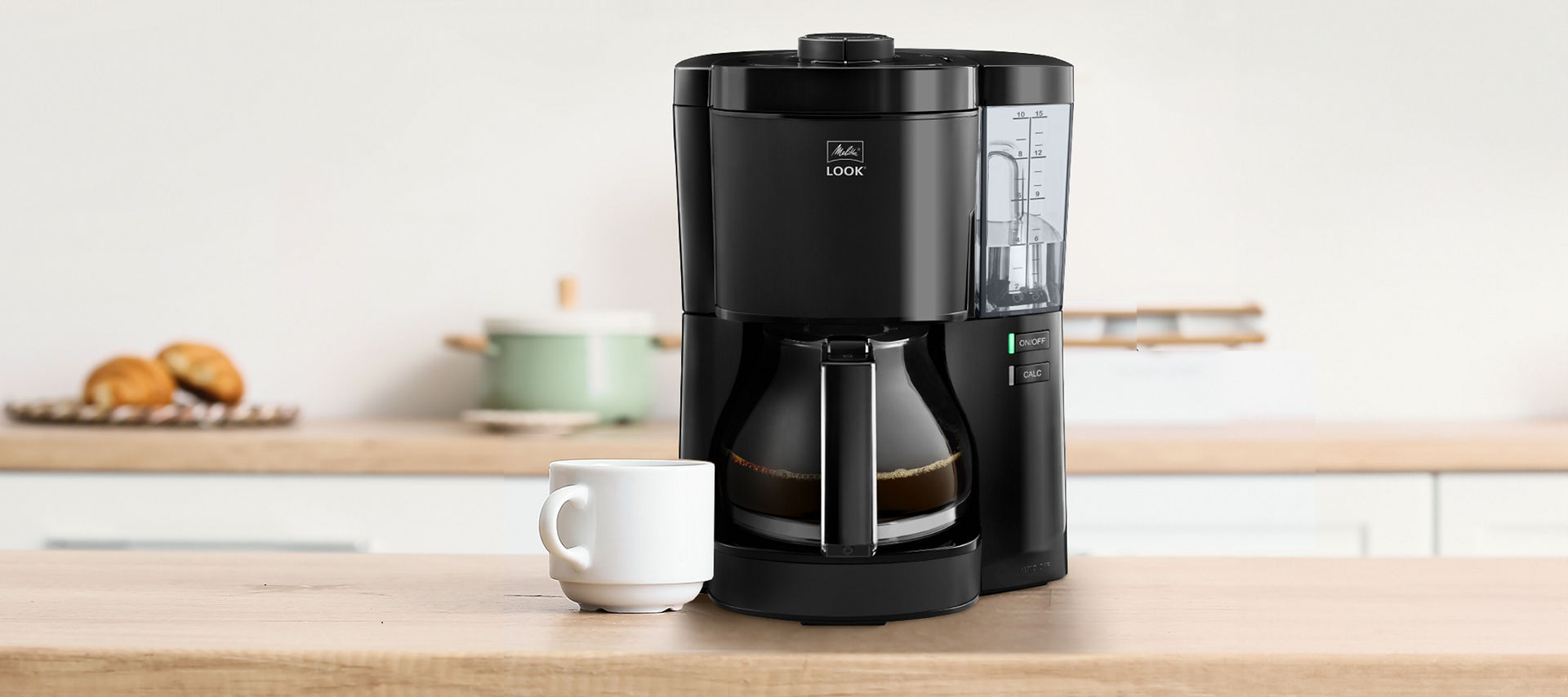 Melitta Filterkaffeemaschine und Kaffeetasse stehen auf einem Küchentresen