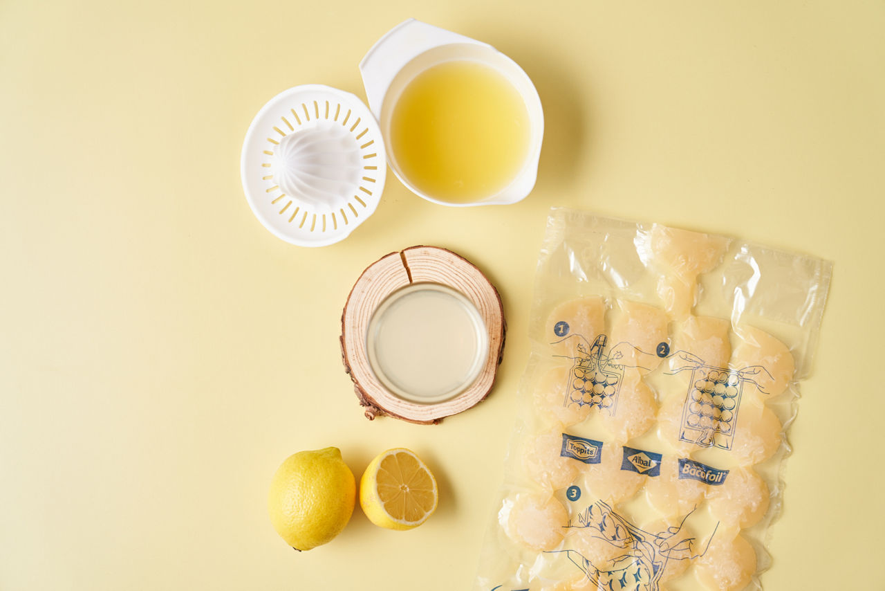 Sachet Glace Pilée Albal rempli de jus de citron congelé, presse-citron rempli de jus et deux citrons