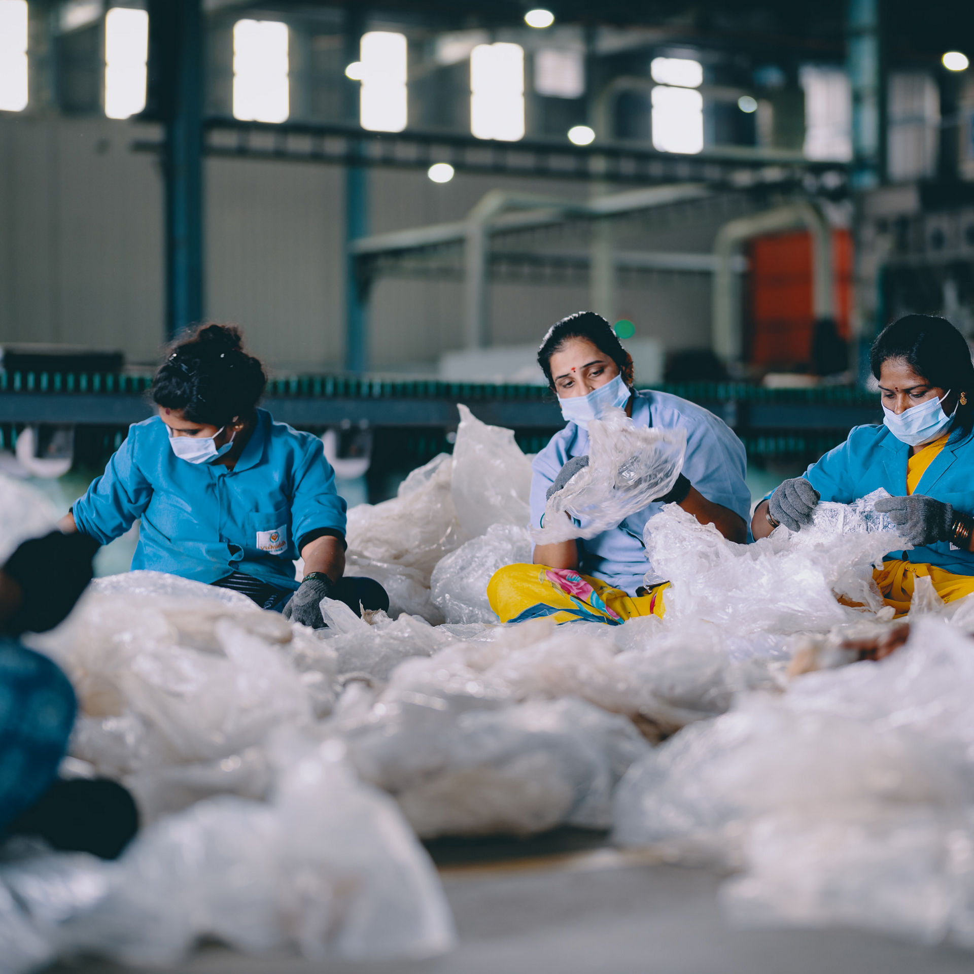 Eine Gruppe von Frauen sitzt auf dem Boden und sortiert Altplastik