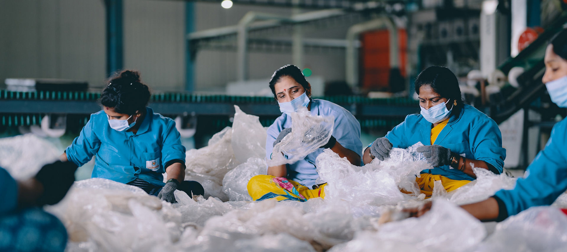 Eine Gruppe von Frauen sitzt auf dem Boden und sortiert Altplastik