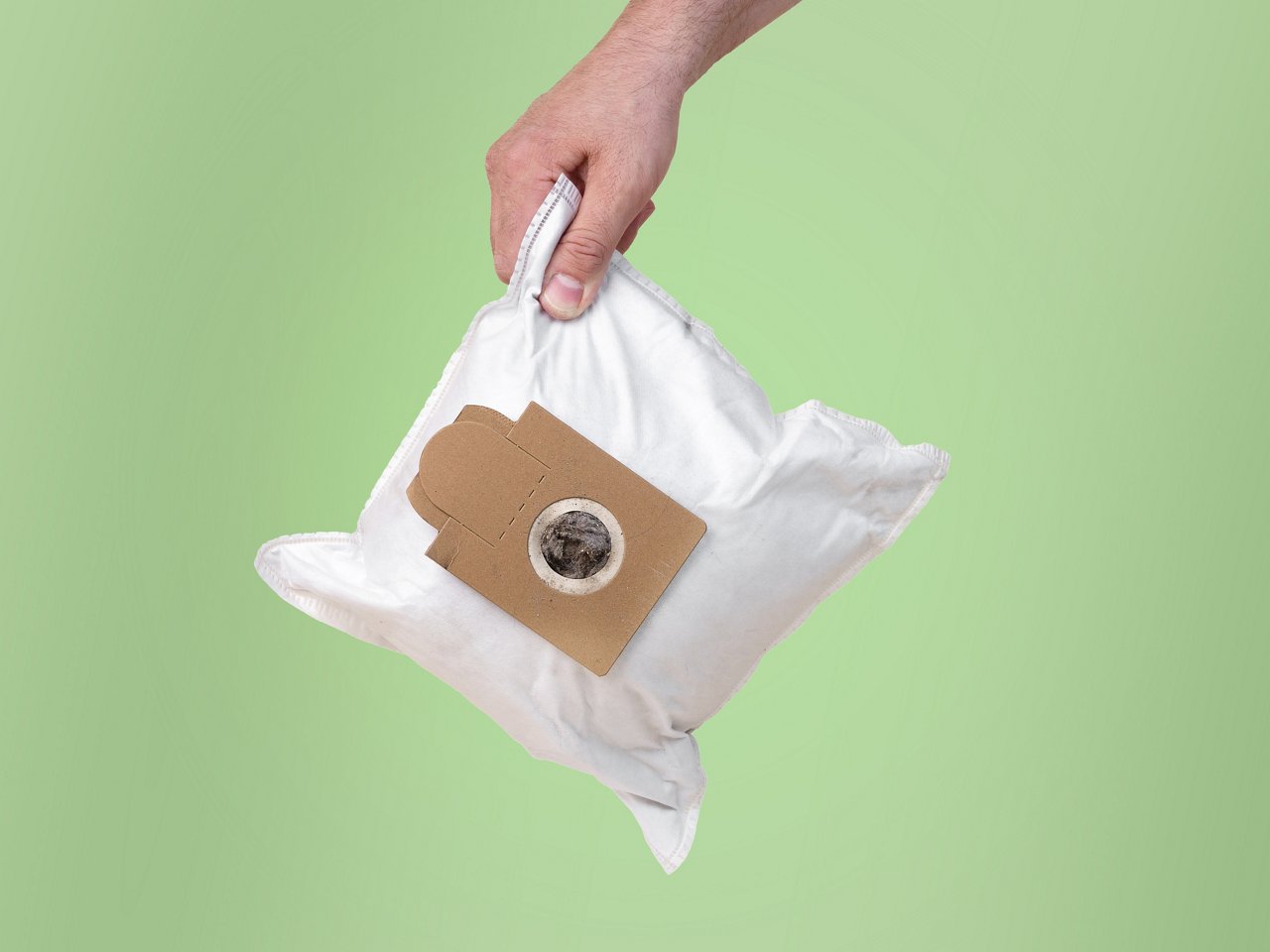 Person hält benutzten Staubsaugerbeutel in der Hand