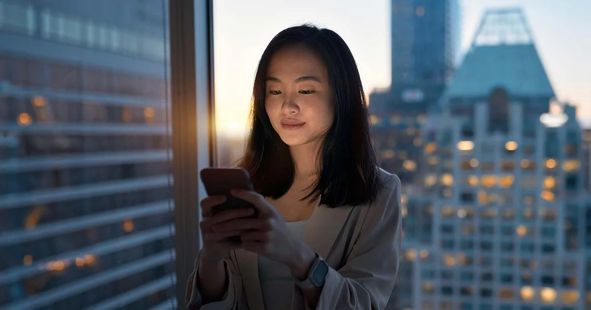 Young woman using smartphone at dusk