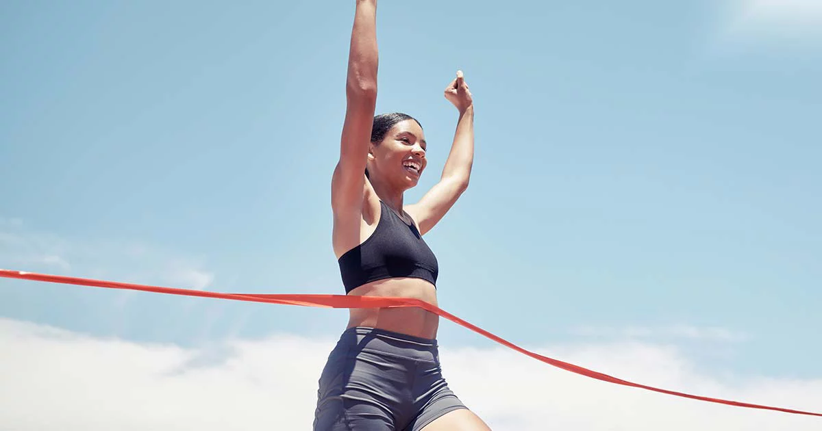 Runner triumphantly crossing finish line outdoors