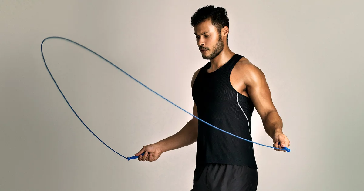 Athletic man training with jump rope