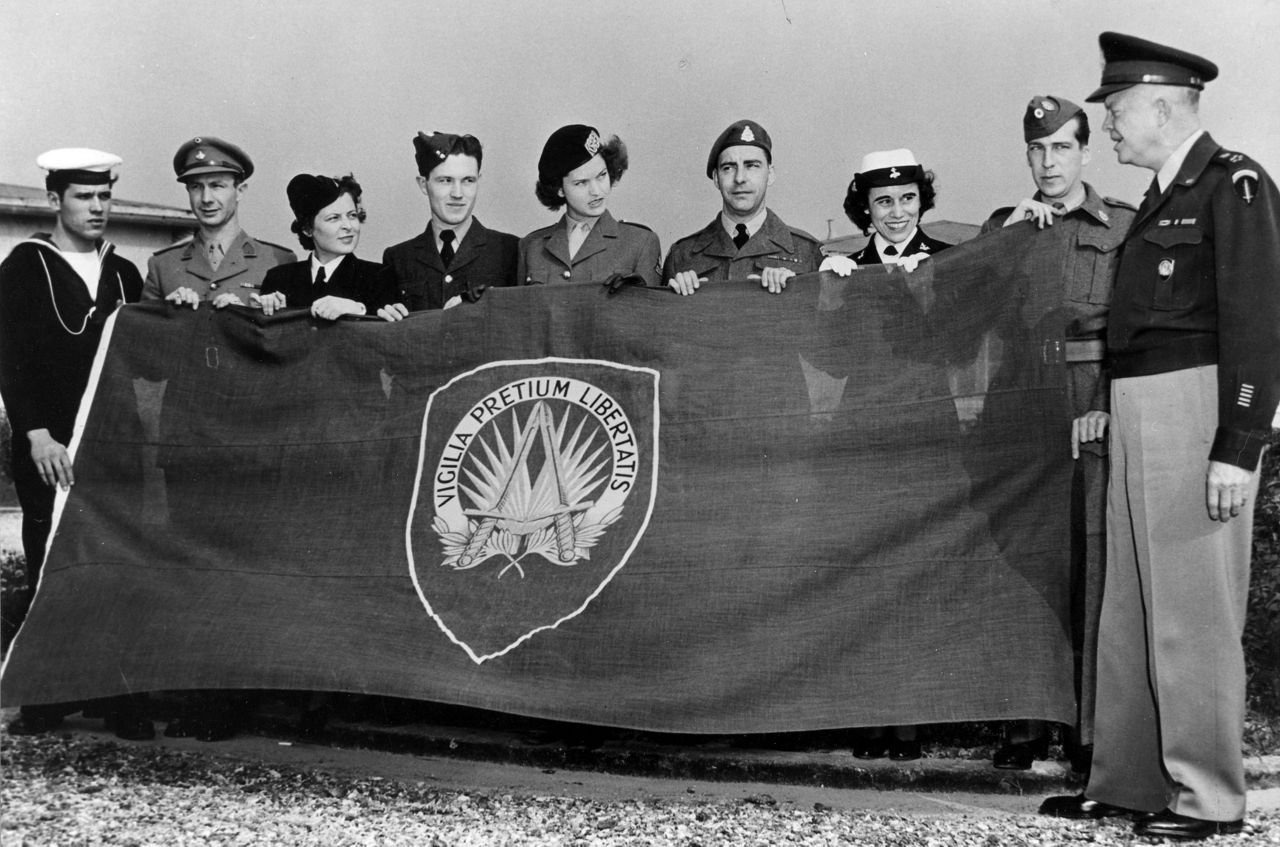 General Dwight D. Eisenhower, NATO’s first Supreme Allied Commander Europe (SACEUR), inspects the new flag for Supreme Headquarters Allied Powers Europe (SHAPE) on the outskirts of Paris in October 1951. 