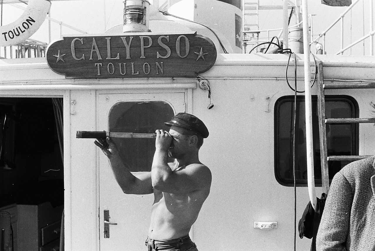 A sailor looks through a spyglass aboard the Calypso – the famous ship captained by oceanographer Jacques Cousteau – during a NATO Science Committee research expedition in the Straits of Gibraltar between the Mediterranean Sea and the Atlantic Ocean.