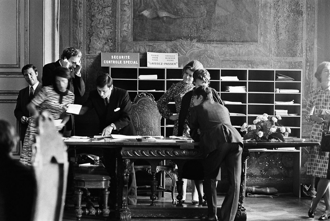 NATO civilian staff are caught up in a flurry of activity in a fancy room at the São Bento Palace during the 1971 NATO ministers’ meeting in Lisbon, Portugal.