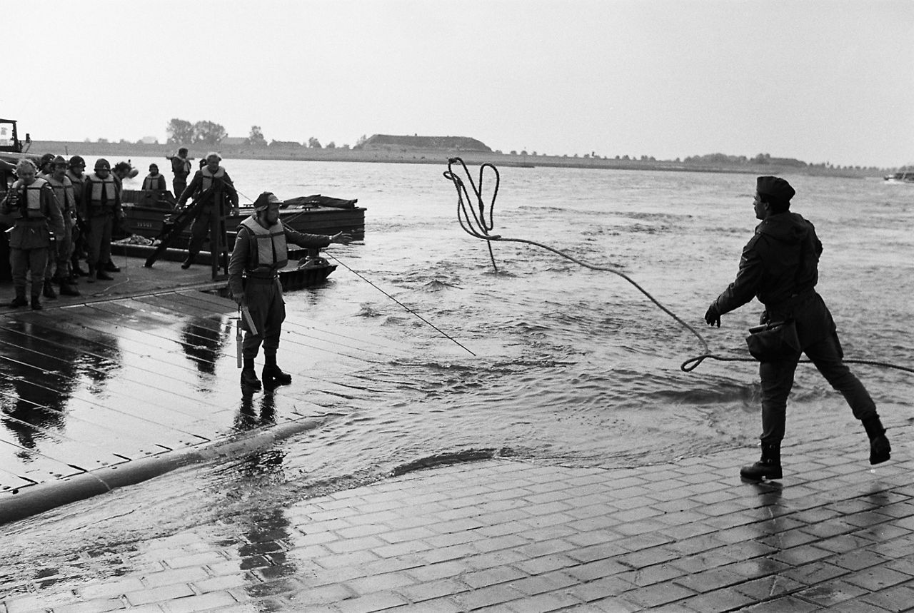 A soldier casts a rope to a sailor on a landing craft during exercise Atlantic Lion 83.