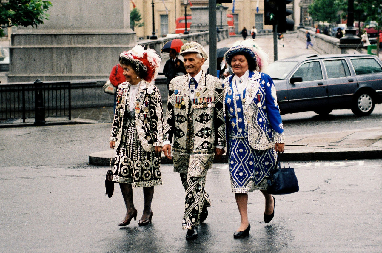 During the 1990 NATO Summit  in London, a group of ‘Pearly Kings and Queens’ – East London residents who sew thousands of buttons into their clothes and raise money for charities – arrives to watch the proceedings.