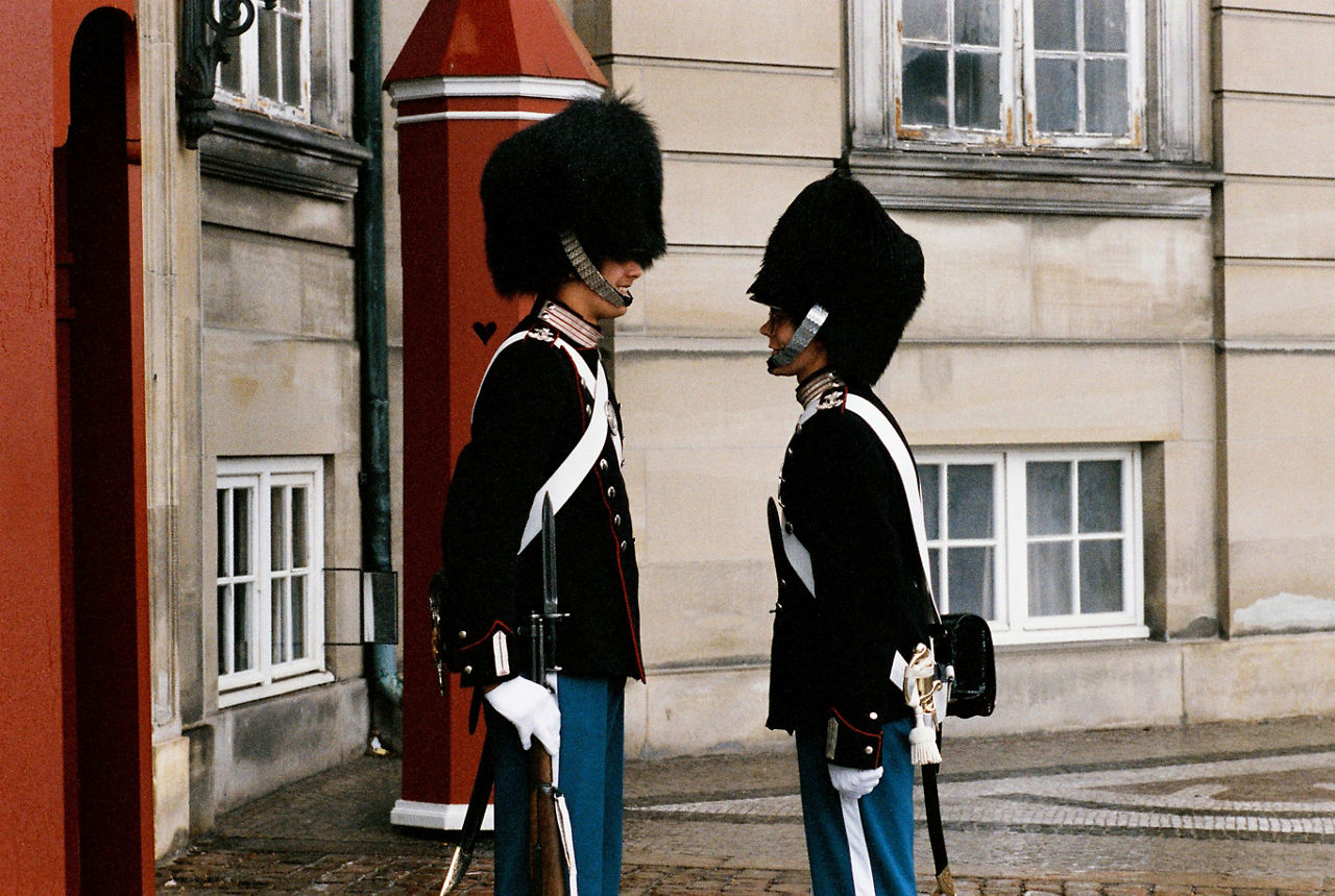Two soldiers grin at each other during the changing of the guard at Amalienborg Palace in Copenhagen, Denmark during a NATO ministerial meeting in June 1991.