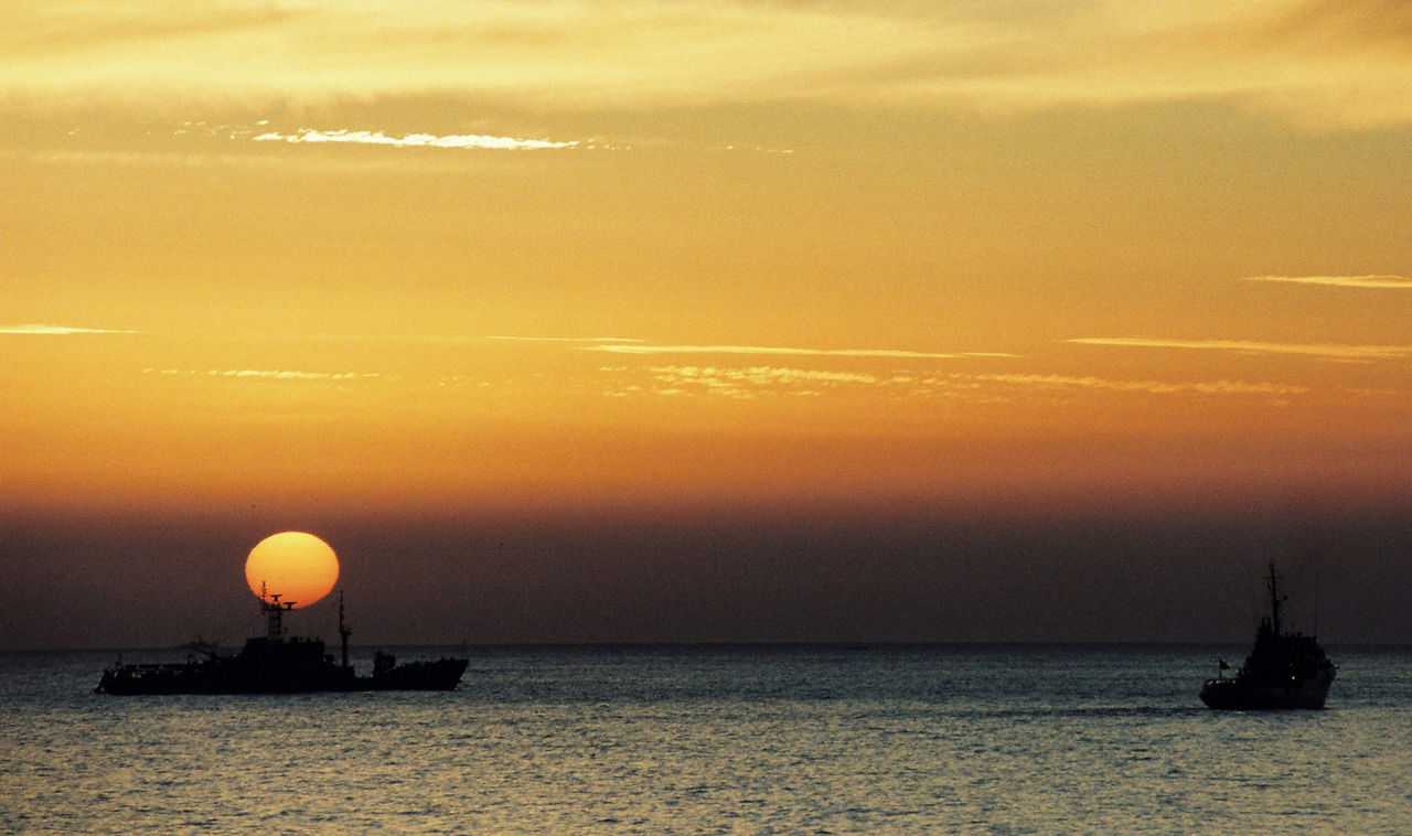 The sun sets behind ships off the coast of Spain and Portugal during exercise Strong Resolve in March 1998.
