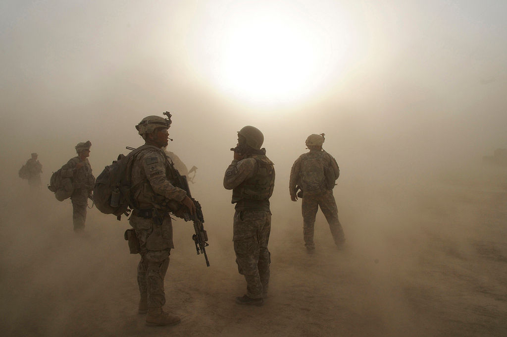 Soldiers wait for a helicopter to land during a dust storm at Forward Operating Base Kushamond, Afghanistan while preparing for an air assault mission. (Photo credit: United States Army)