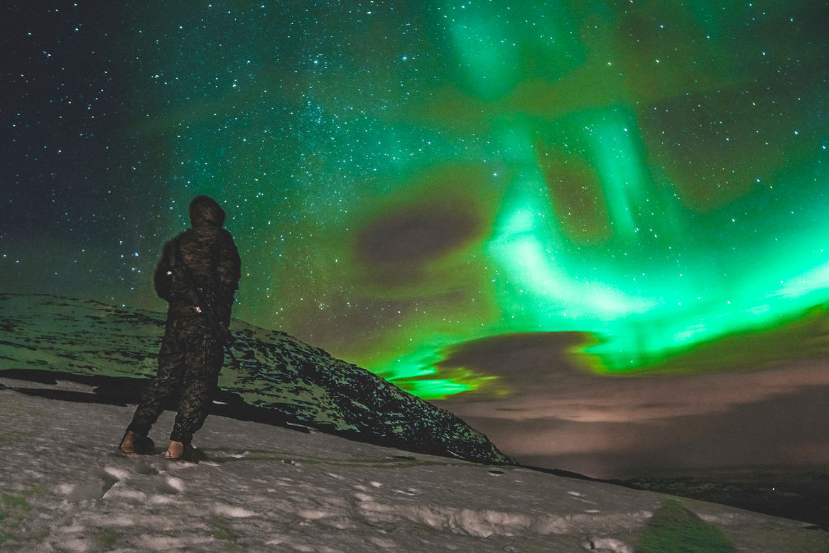 A soldier looks up in wonder at the northern lights during exercise Reindeer II in Norway. (Photo credit: Cpl. William Chockey, United States Marine Corps)