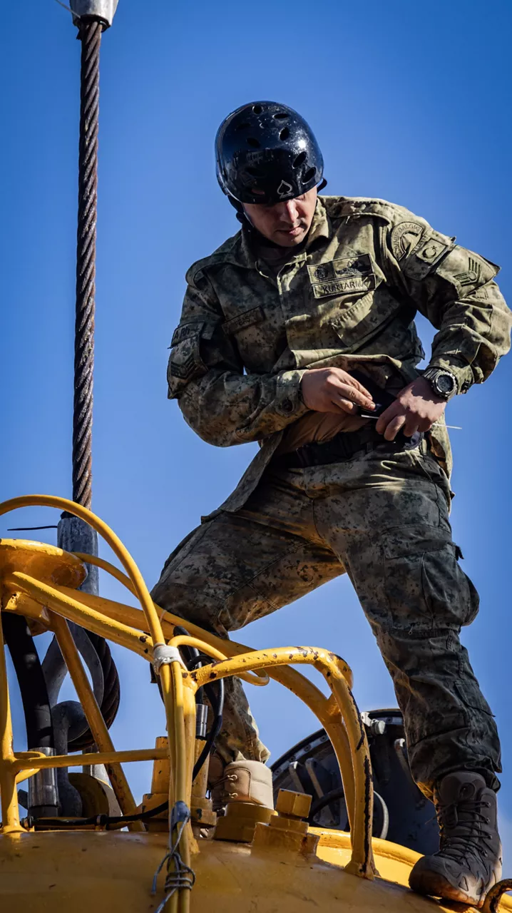 Turkish Navy crew member on board the TCG Alemdar prepares to lower the ship's rescue chamber into the North Sea during Dynamic Monarch 24.

At Dynamic Monarch 24, the world’s most challenging submarine rescue exercise, Allies are testing various complex submarine rescue systems. The exercise is designed to practise interoperability among naval forces and streamline rescue operations in the most challenging of environments where reaction time and specialist equipment are key to saving lives. Dynamic Monarch 24 is taking place off the coast of Norway.