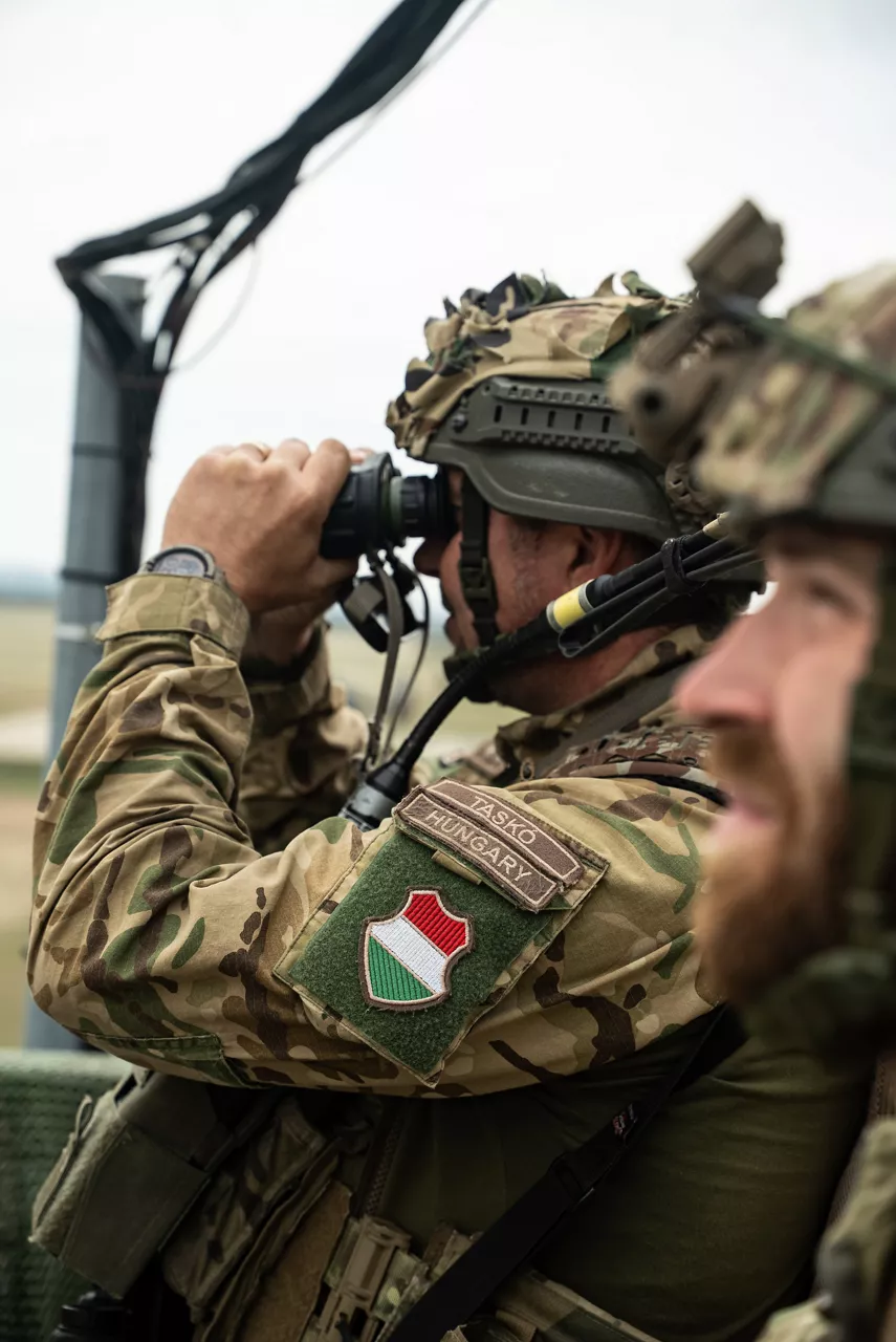 A Hungarian Army Joint Terminal Attack Controller (JTAC) looks through his binoculars after calling in a simulated airstrike. Exercise Adaptive Hussars 2025 was the Hungarian Defence Forces’ largest and most complex military exercise since Hungary’s accession to NATO in 1999. It promoted cooperation between all NATO members contributing to the NATO’s multinational battlegroup in Hungary, and boosted Hungary’s  defence capabilities along with NATO defence plans and procedures.