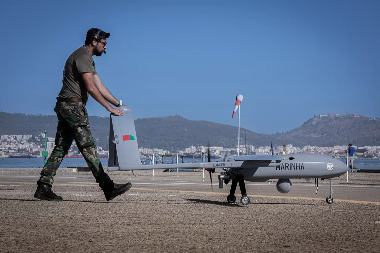 Portuguese soldier demonstrates unmanned aerial vehicle at REPMUS 2025.

During Exercises REPMUS and Dynamic Messenger 2025, NATO united Allied forces, partners, industry, and researchers to trial uncrewed systems, advanced sensing, and communications in real-life tests scenarios at sea. NATO’s Defence Innovation Accelerator (DIANA) helps turn new ideas into real capabilities by connecting innovators with real-world trials, making it easier for Allies to adopt technology, work together, and use innovative technologies to strengthen defence.