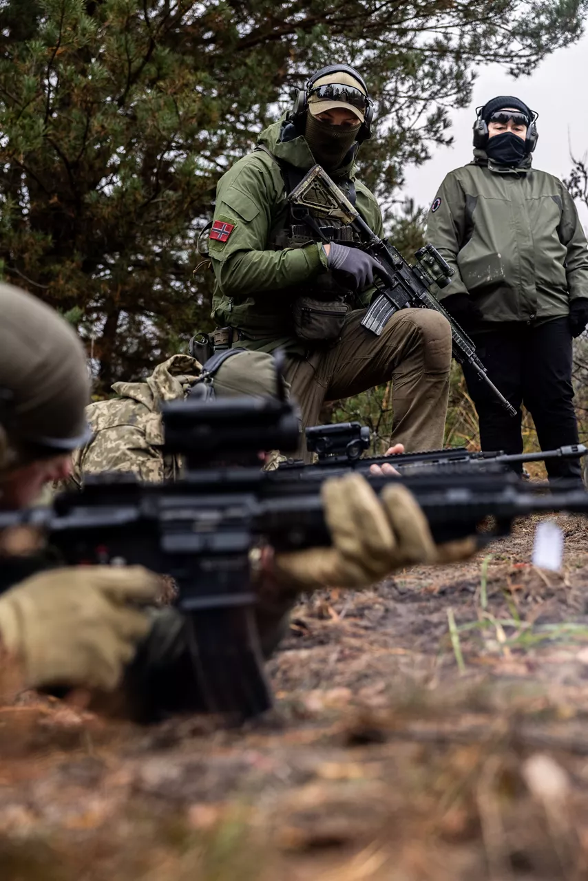 An infantry trainer from Norway’s Telemark Battalion instructs a group of Ukrainian soldiers on trench-clearing tactics at Camp Jomsborg in Poland. 

Camp Jomsborg was set up earlier this year as part of Operation Legio, an effort to train, equip and fund Ukraine’s armed forces, and is supported by Denmark, Estonia, Finland, Latvia, Lithuania, Norway, Sweden and Poland. Norway leads Legio, and its trainers work side-by-side with counterparts from the Estonian Army to equip Ukraine’s soldiers with the skills they need to fight and prevail on the battlefield.

