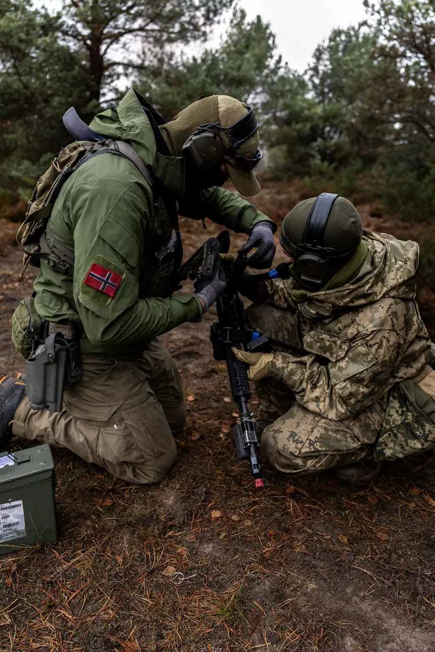 A Norwegian Army infantry trainer helps a Ukrainian soldier clear a jam from his rifle during a trench-clearing tactics class held at Camp Jomsborg in Poland. 

Camp Jomsborg was set up earlier this year as part of Operation Legio, an effort to train, equip and fund Ukraine’s armed forces, and is supported by Denmark, Estonia, Finland, Latvia, Lithuania, Norway, Sweden and Poland. Norway leads Legio, and its trainers work side-by-side with counterparts from the Estonian Army to equip Ukraine’s soldiers with the skills they need to fight and prevail on the battlefield.