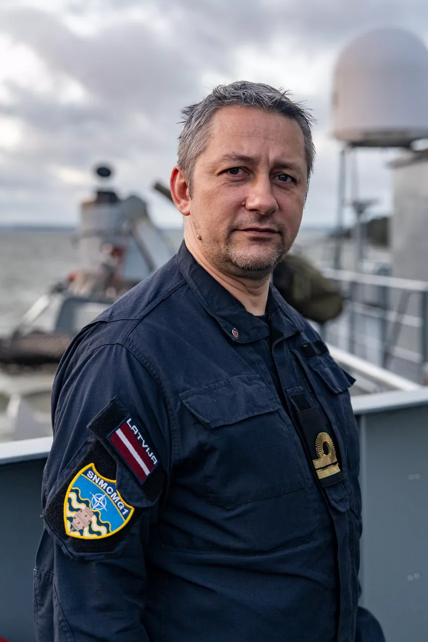 The commanding officer of SNMCMG1’s flagship, LVNS Virsaitis, looks toward the camera while sailing during exercise Freezing Winds.

NATO and its Allies are intensifying efforts to protect vital sea routes and critical infrastructure. Exercise Freezing Winds 2025 brought together ships from Standing NATO Mine Countermeasures Group One (SNMCMG1) and other Allied units to train side by side in the Baltic Sea’s harsh winter conditions. Over several days, naval forces, divers, and mine counter-measure teams practised joint operations to ensure readiness against diverse threats — from detecting and neutralising underwater threats to responding to disruptions affecting vital sea lines of communication. This exercise complements NATO’s Baltic Sentry enhanced vigilance activity, launched in January 2025 to strengthen surveillance and monitoring across the region. The exercise took place from 24 November to 4 December 2025.