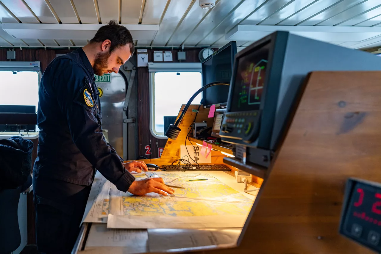 A Latvian sailor aboard SNMCMG1’s flagship LVNS Virsaitis studies a map while sailing during exercise Freezing Winds.

NATO and its Allies are intensifying efforts to protect vital sea routes and critical infrastructure. Exercise Freezing Winds 2025 brought together ships from Standing NATO Mine Countermeasures Group One (SNMCMG1) and other Allied units to train side by side in the Baltic Sea’s harsh winter conditions. Over several days, naval forces, divers, and mine counter-measure teams practised joint operations to ensure readiness against diverse threats — from detecting and neutralising underwater threats to responding to disruptions affecting vital sea lines of communication. This exercise complements NATO’s Baltic Sentry enhanced vigilance activity, launched in January 2025 to strengthen surveillance and monitoring across the region. The exercise took place from 24 November to 4 December 2025.