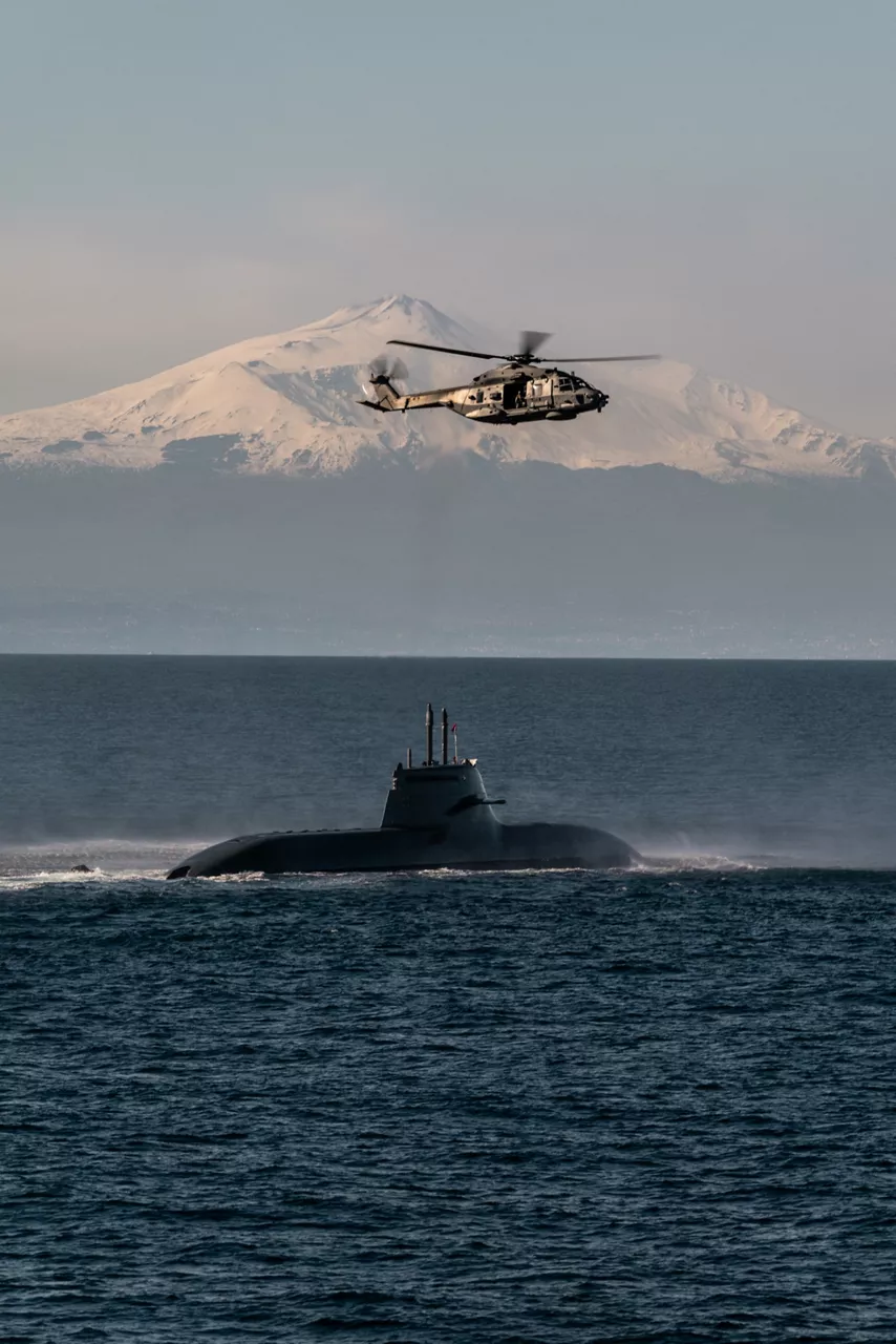 An Italian Navy helicopter hovers over an Italian Navy submarine during Exercise Dynamic Manta 26. The exercise, held annually by NATO Allied Maritime Command, tests Allied Anti-Submarine Warfare capabilities in a series of sub-hunting drills off the coast of Sicily. This year’s iteration gathered ship, submarines and aircraft from nine Allies, including Canada, France, Germany, Greece, Italy, Portugal, Türkiye, the United Kingdom and the United States.