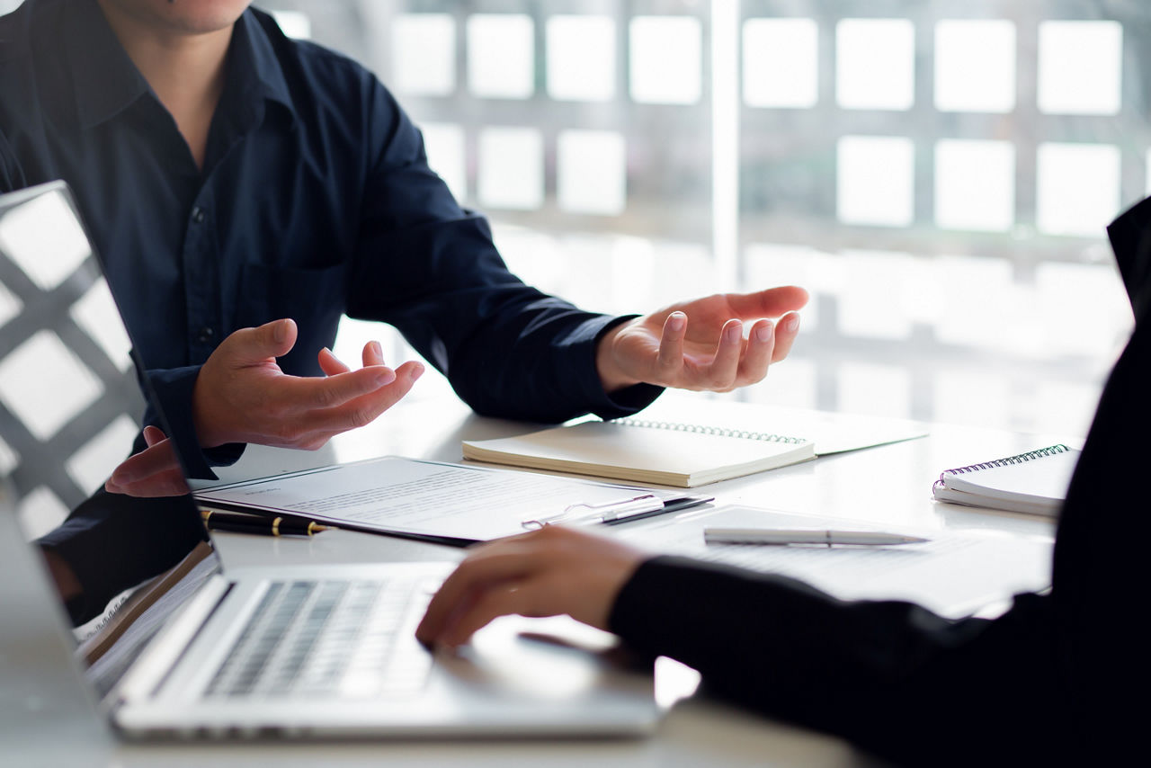 Male employer holding resume talking with female job candidate at interview, black millennial girl recruitment process, speak with HR 