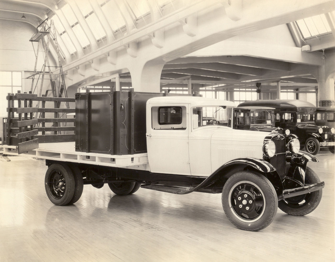 Circa 1931: An Omaha Standard stake-body truck displayed in a product showroom. Vehicles like these helped establish a century-long legacy of craftsmanship, innovation, and purpose-built work-truck solutions that continue under PALFINGER today.