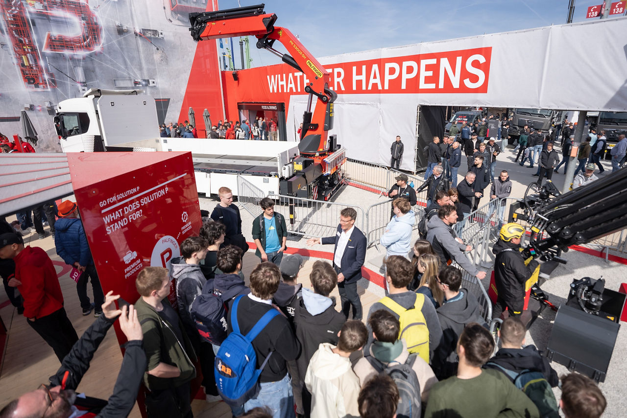 Exhibitor visitors experiencing the exciting new offerings from PALFINGER at a trade fair