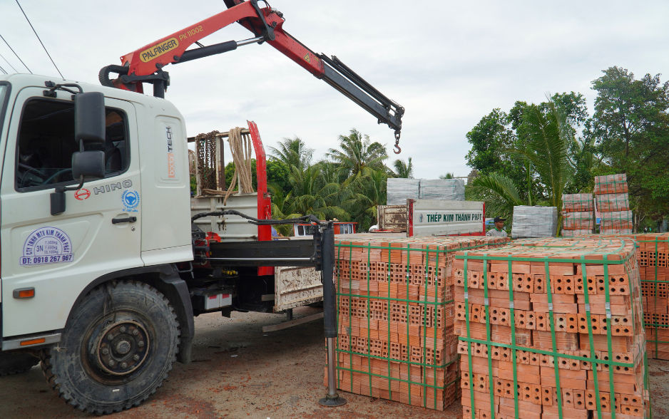 Xe gắn cẩu gập Palfinger tại kho bãi xây dựng.png