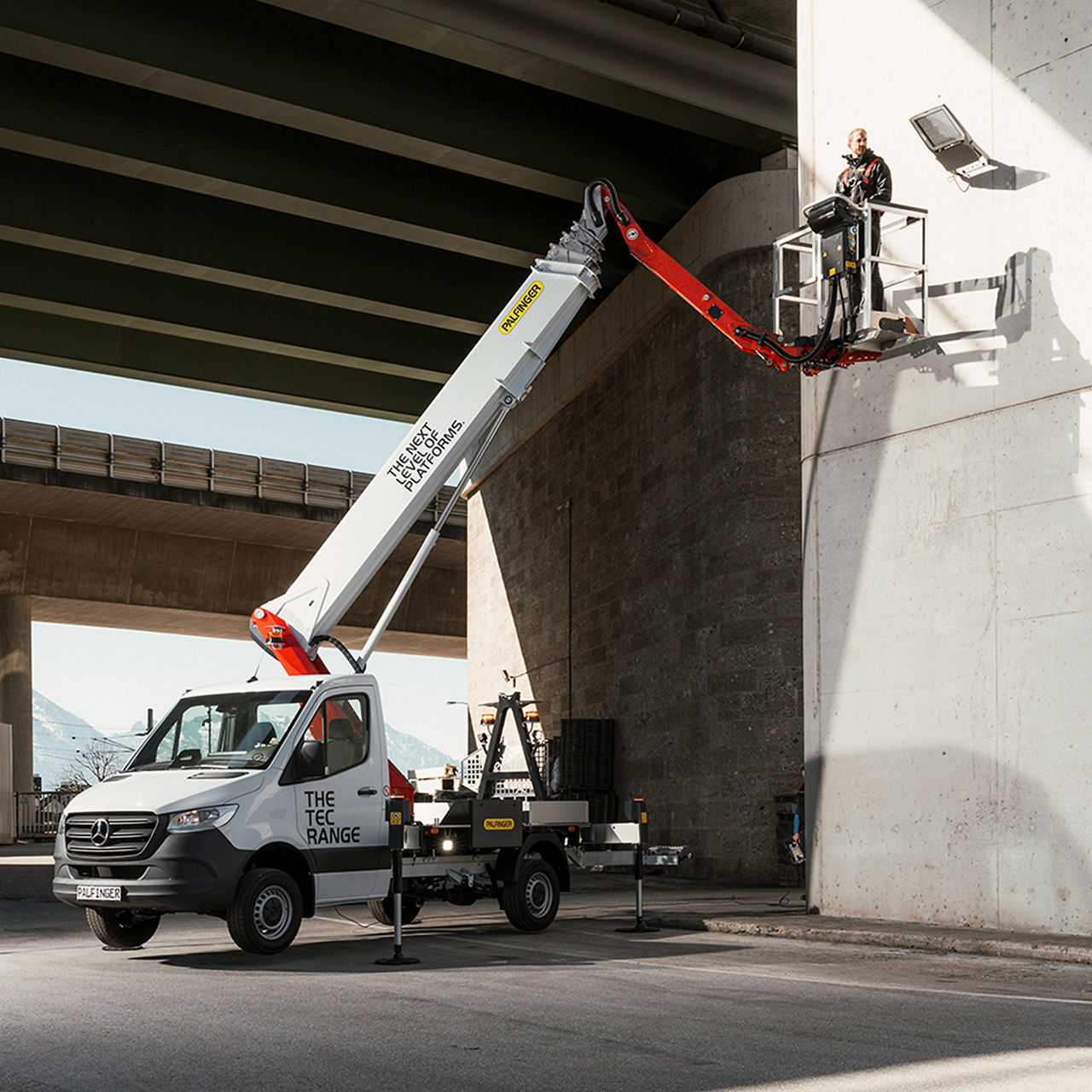 Close-up of a tablet displaying the PALFINGER website, highlighting business segments and a corporate mission statement.